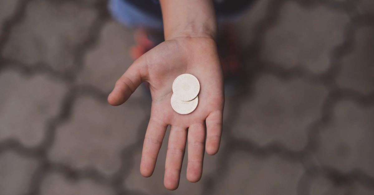 Gold coins in the palm of a person's hand; answering the question, 'Why did Judas betray Jesus?'