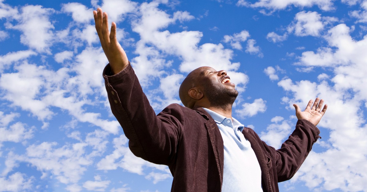 Man worshipping outside; nonbelievers question whether Easter is a time to mourn or celebrate.